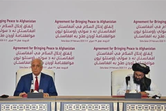 Đặc phái viên Mỹ về vấn đề tái hòa giải Afghanistan Zalmay Khalilzad (trái) và nhà đồng sáng lập phong trào Taliban Mullah Abdul Ghani Baradar tại lễ ký thoả thuận hoà bình ở Doha (Qatar), ngày 29/2/2020. (Ảnh: AFP/TTXVN)