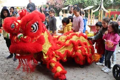 Màn múa lân thu hút sự tò mò, thích thú của các em nhỏ tại Brussels (Bỉ). (Ảnh: Hương Giang/TTXVN)