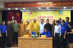 Đại diện hai đơn vị ký kết chương trình hợp tác tổ chức các hoạt động an sinh xã hội. (Ảnh: PV/Vietnam+)