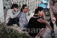 Công ty GMIE (Bắc Ninh) bất ngờ dừng hoạt động, công nhân tụ tập trước cửa công ty để chờ giải quyết các chính sách bảo hiểm. (Ảnh: PV/Vietnam+)