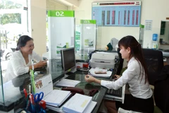 Giao dịch tại Ngân hàng Vietcombank chi nhánh Gia Lai. (Ảnh: Hoàng Hùng/TTXVN)