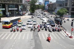 Nắng nóng là một cực hình với người tham gia giao thông trong những ngày này. (Ảnh: Minh Quyết/​TTXVN)