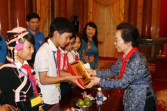 Phó Chủ tịch nước Nguyễn Thị Doan tặng quà các em có hoàn cảnh đặc biệt khó khăn, trẻ em nghèo hiếu học, học giỏi trên toàn quốc. (Ảnh: Phạm Kiên/TTXVN)