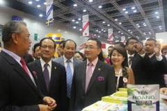 Phó Thủ tướng Malaysia Muhyiddin Yassin (đi đầu) và Tổng Thư ký ASEAN Lê Lương Minh (thứ hai) thăm gian hàng của Việt Nam. (Ảnh: Kim Dung-Chí Giáp/Vietnam+)
