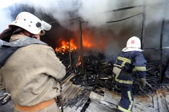 Lính cứu hỏa dập lửa đám cháy khu chợ ở Donetsk sau vụ pháo kích trong xung đột. (Nguồn: AFP/TTXVN)