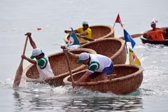 Hội thi bơi thúng, lắc thúng trong khuôn khổ Festival Biển Nha Trang 2013. (Ảnh: Thanh Hà/TTXVN)