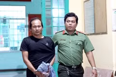Lực lượng Công an bắt, áp giải Nguyễn Hoàng Nam về nơi giam giữ. (Ảnh: TTXVN phát)