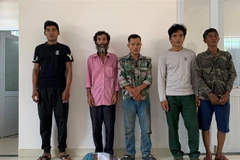 Nhóm đối tượng và tang vật tại cơ quan Công an. (Ảnh: TTXVN phát)