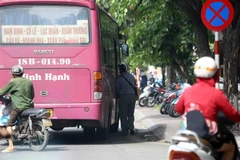 Dù đã có biển báo cấm dừng, cấm đỗ nhưng nhiều trường hợp xe khách vẫn cố tình dừng đỗ đón, trả khách sai quy định. (Ảnh: Phạm Kiên/TTXVN)
