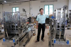 Anh Nguyễn Hồng Chương giới thiệu máy gieo hạt chân không 6 trong 1. (Ảnh: Chu Quốc Hùng/TTXVN)
