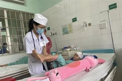 Bệnh nhi N.T.H. được theo dõi sức khỏe sau ca phẫu thuật và chờ ghép lại xương sọ tại Bệnh viện Nhi đồng Đồng Nai. (Ảnh: Lê Xuân/TTXVN)