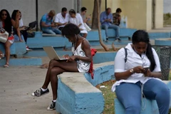 Người dân truy cập Internet trên điện thoại di động tại La Habana, Cuba. (Ảnh: AFP/TTXVN)