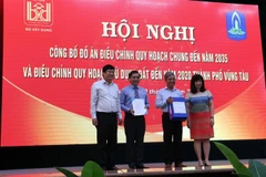 Đại diện Bộ Xây dựng trao Quyết định, tài liệu điều chỉnh quy hoạch cho lãnh đạo tỉnh Bà Rịa-Vũng Tàu và thành phố Vũng Tàu. (Ảnh: Đoàn Mạnh Dương/TTXVN)