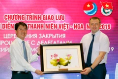 Đại diện Thành Đoàn Thanh niên Cộng sản Hồ Chí Minh tặng quà lưu niệm cho ông Alexander Bugaev (Ảnh: Hoàng Hải/TTXVN)