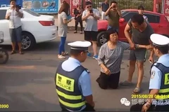 Cảnh sát giao thông Trung Quốc quỳ xuống đất để giải thích cho dân 