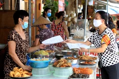 Các thành viên Ban Chỉ đạo phòng, chống dịch COVID-19 phường Máy Tơ, Hải Phòng, hướng dẫn bà con Tiểu thương thực hiện nghiêm các cam kết phòng chống dịch. (Ảnh: An Đăng - TTXVN)