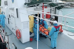 Bệnh nhân Kaidalov Oleksandr được lực lượng cứu hộ đưa từ tàu SAR27-01 lên bờ sau khi cập cảng Nha Trang an toàn. (Ảnh: TTXVN)