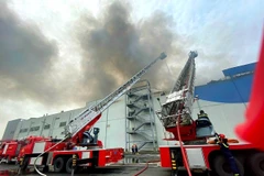 Lực lượng cảnh sát phòng cháy chữa cháy nỗ lực khống chế đám cháy. (Ảnh: TTXVN phát)