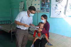 Cán bộ y tế địa phương phát tờ rơi tuyên truyền về bệnh bạch hầu để người dân phòng tránh. (Ảnh: Hồ Cầu/TTXVN)