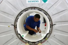 Một nhân viên làm việc trên một máy chụp ảnh cộng hưởng từ tại một dây chuyền sản xuất của Siemens Healthineers ở Thâm Quyến, Trung Quốc ngày 25/5/2018. (Nguồn: Reuters)