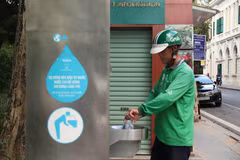 Người dân sử dụng nước ở trụ nước sạch miễn phí được đặt tại quận Hoàn Kiếm (Hà Nội). (Ảnh: Mạnh Khánh/TTXVN)