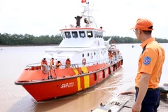 Lực lượng cứu hộ đưa thuyền viên bị nạn của tàu cá TH 90282 TS về bờ. (Ảnh: Trần Hoàng Ngọc/TTXVN)