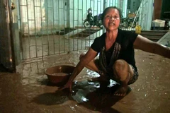 Người dân vất vả dọn dẹp bùn đất. (Ảnh: Nguyễn Chiến/TTXVN)