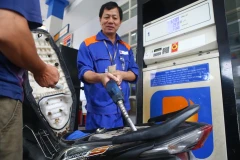 Nhân viên Petrolimex đang bán xăng cho khách hàng. (Ảnh: Minh Quyết/TTXVN)