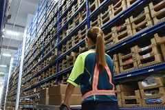 Một nhân viên nhận đơn đặt hàng từ các kệ hàng trong nhà kho tại Trung tâm hậu cần thương mại điện tử khu vực SingPost ở Singapore. (Ảnh: AFP)