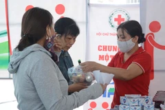 Người dân được phát miễn phí một số nhu yếu phẩm. (Ảnh: Văn Dũng/TTXVN)
