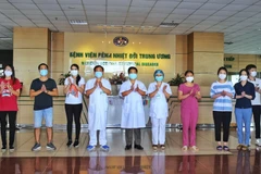 Các bác sỹ Bệnh viện bệnh nhiệt đới Trung ương chúc mừng bệnh nhân được công bố khỏi bệnh COVID-19 ngày 14/5. (Ảnh: Danh Lam/TTXVN)