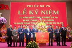 Ông Đặng Xuân Phong, Bí thư tỉnh ủy, Chủ tịch ủy ban nhân dân tỉnh Lào Cai trao bức trướng chúc mừng Đảng bộ thị xã Sa Pa. (Ảnh: Quốc Khánh/TTXVN)