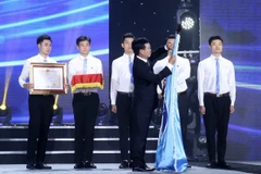 Trưởng Ban Tuyên giáo Trung ương Võ Văn Thưởng gắn Huân chương Độc lập hạng Nhất (lần thứ II) của Chủ tịch nước lên lá cờ của Hội Sinh viên Việt Nam. (Ảnh: Văn Điệp/TTXVN)