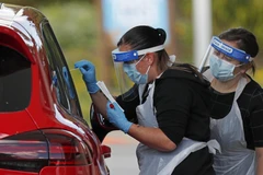 Nhân viên y tế lấy mẫu xét nghiệm COVID-19 cho người dân tại Chessington, phía Tây Nam London, Anh. (Ảnh: AFP/TTXVN)