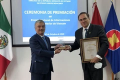 Đại sứ Nguyễn Hoài Dương trao giải cho ông Mouris Salloum George, Chủ tịch Câu lạc bộ Tiếng nói các nhà báo và Tổng biên tập Tạp chí Voces của Mexico. (Ảnh: Việt Hùng/TTXVN)