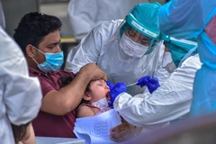 Nhân viên y tế lấy mẫu dịch xét nghiệm COVID-19 cho trẻ em tại Kuala Lumpur, Malaysia. Đường cong dịch bệnh ở nước này "đã được làm phẳng." (Ảnh: THX/TTXVN)