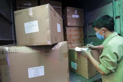 Lực lượng Quản lý thị trường Hà Nội niêm phong, lập biên bản tạm giữ số hàng vật tư, thiết bị y tế, các loại kit thử nhanh, máy đo nước tiểu, đo huyết áp… do nước ngoài sản xuất nhưng không có hóa đơn chứng từ. (Ảnh: Trần Việt/TTXVN)