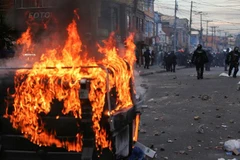 Người biểu tình phóng hỏa đốt thùng rác trên đường phố. (Nguồn: Reuters)