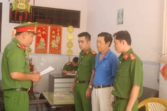 Cơ quan Cảnh sát điều tra Công an tỉnh Trà Vinh tống đạt quyết định khởi tố bị can, bắt tạm giam Trầm Ngọc Long. (Ảnh: Thanh Hòa/TTXVN)