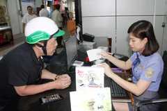 Nhân viên tại Ga Sài Gòn hướng dẫn hành khách thủ tục mua vé tàu. (Ảnh: Tiến Lực/TTXVN)