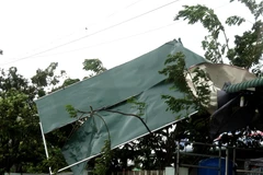 Nhiều mái tôn tại nhà dân bị gió cuốn phăng. (Ảnh: Lê Ngọc Phước/TTXVN)
