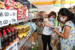 Các tình nguyện viên hỗ trợ người nghèo, người khuyết tật bị ảnh hưởng bởi dịch bệnh COVID-19 mua sắm miễn phí tại siêu thị hạnh phúc 0 đồng. (Ảnh: Thanh Vũ/TTXVN)