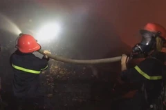 Lực lượng cứu hỏa nỗ lực dập tắt đám cháy. (Ảnh: TTXVN)