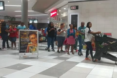 Người dân xếp hàng trong trung tâm thương mại Menlyn tại thủ đô Pretoria tối 26/3 để mua lương thực, thực phẩm tích (Ảnh: Phi Hùng/TTXVN)