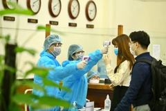 [Photo] Cán bộ, viên chức đo thân nhiệt, đeo khẩu trang ở nơi làm việc