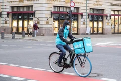 Nhân viên giao hàng đeo khẩu trang phòng dịch COVID-19 đi trên đường phố vắng vẻ tại Berlin, Đức ngày 26/11/2020. (Ảnh: THX/TTXVN)