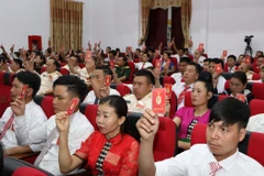 Các đại biểu biểu quyết thông qua Nghị quyết Đại hội tại phiên bế mạc Đảng bộ huyện Tân Uyên khóa XVIII, nhiệm kỳ 2020-2025. (Ảnh: Quý Trung/TTXVN)