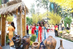 Các bạn trẻ chụp ảnh tại Lễ hội Tết Việt với nét mộc mạc của làng quê, hay một góc Sài Gòn xưa. (Ảnh: Thanh Vũ - TTXVN)