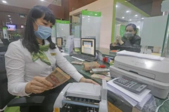 Khách hàng giao dịch tại hội sở chính Vietcombank, 198 Trần Quang Khải, Hà Nội. (Ảnh: Trần Việt/TTXVN)