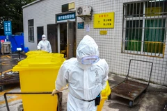 Công nhân môi trường vận chuyển các thùng chứa chất thải y tế tại một bệnh viện ở Vũ Hán, Trung Quốc ngày 2/3/2020. (Ảnh: THX/TTXVN)